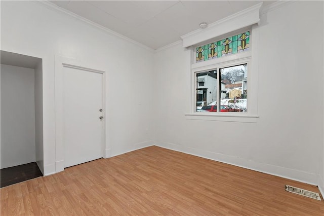 empty room with crown molding and hardwood / wood-style flooring