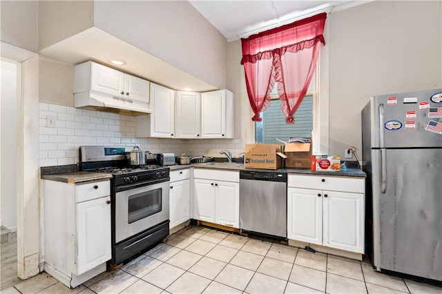 kitchen with light tile patterned flooring, sink, white cabinetry, appliances with stainless steel finishes, and backsplash