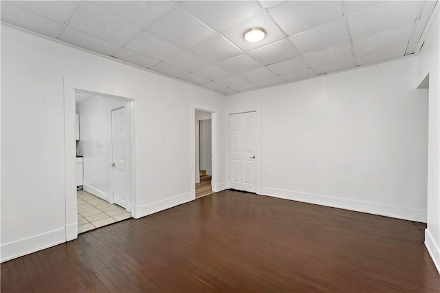 empty room featuring a drop ceiling and light hardwood / wood-style flooring