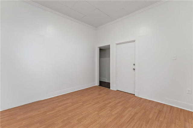 empty room with ornamental molding and light hardwood / wood-style flooring