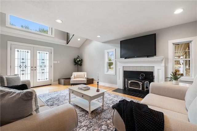 living room with lofted ceiling, hardwood / wood-style floors, and french doors