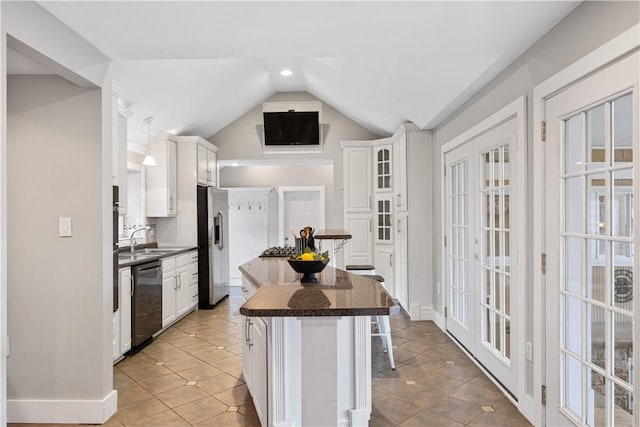 kitchen featuring vaulted ceiling, white cabinetry, a kitchen breakfast bar, a center island, and stainless steel appliances