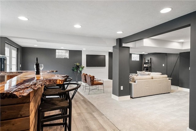 living room featuring a textured ceiling and light hardwood / wood-style flooring