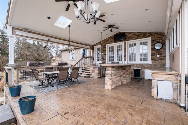 view of patio / terrace with wine cooler, an outdoor bar, ceiling fan, and an outdoor kitchen