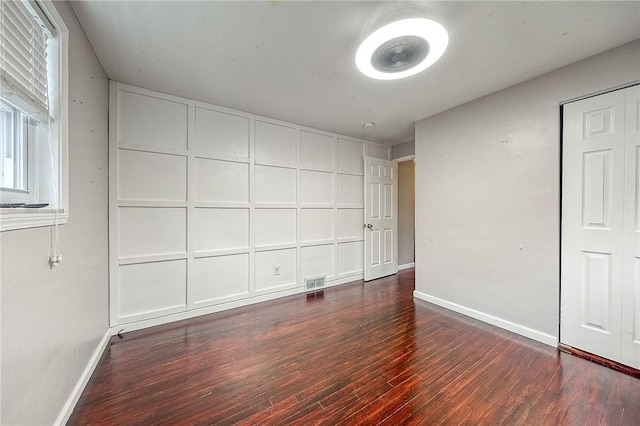 unfurnished bedroom with dark hardwood / wood-style flooring