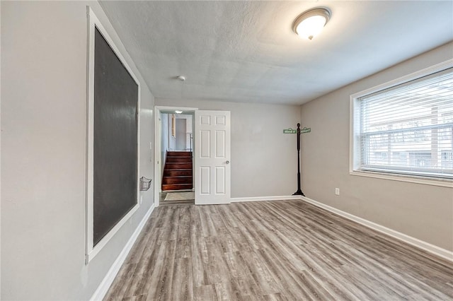 spare room with light hardwood / wood-style floors and a textured ceiling