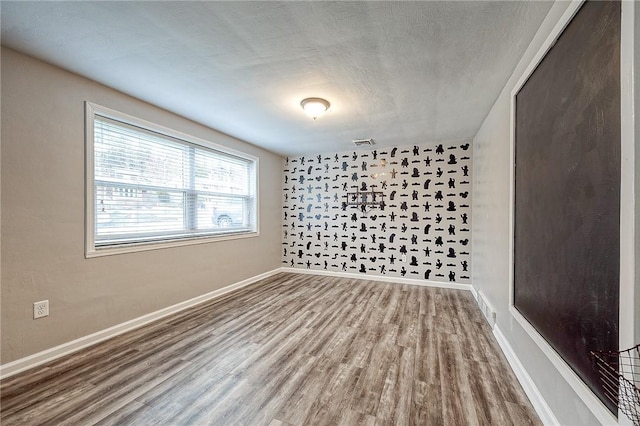 empty room featuring wood-type flooring and a textured ceiling