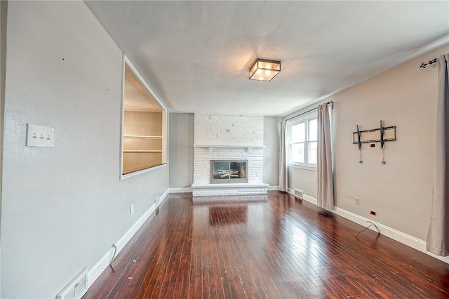 unfurnished living room with hardwood / wood-style flooring, a fireplace, and built in shelves