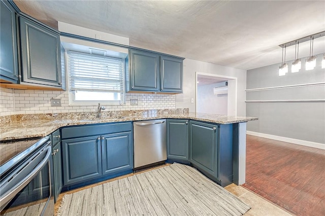 kitchen with backsplash, kitchen peninsula, stainless steel appliances, light stone countertops, and blue cabinetry