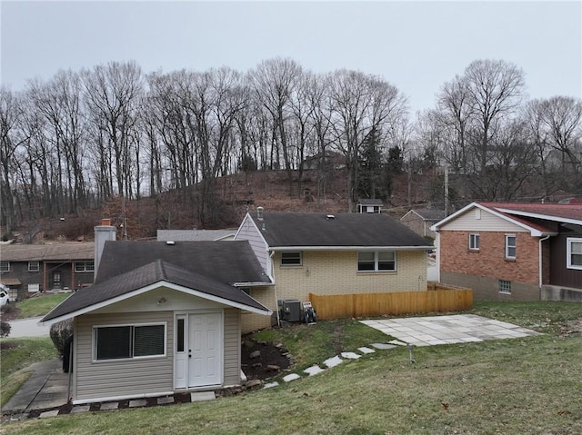 back of house featuring a yard, central AC unit, and a patio