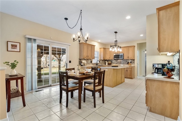 dining room with sink, light tile patterned floors, and an inviting chandelier