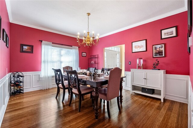 dining room featuring crown molding, hardwood / wood-style flooring, and a chandelier