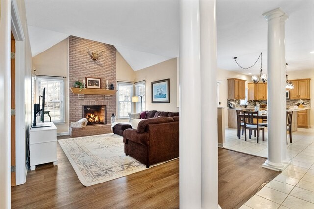 living room featuring a healthy amount of sunlight, light hardwood / wood-style floors, and ornate columns