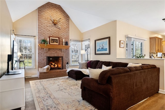 living room with hardwood / wood-style flooring, a brick fireplace, and high vaulted ceiling