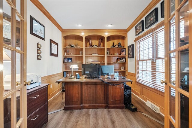 office featuring crown molding, light hardwood / wood-style flooring, french doors, and built in shelves