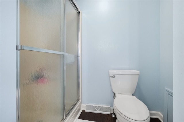 bathroom featuring an enclosed shower, hardwood / wood-style floors, and toilet