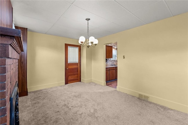 carpeted empty room featuring a chandelier