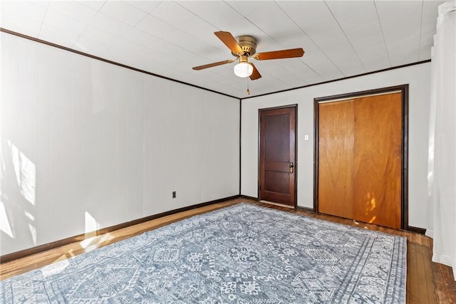 unfurnished bedroom featuring ornamental molding, wood-type flooring, and ceiling fan