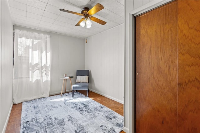 living area with parquet floors and ceiling fan