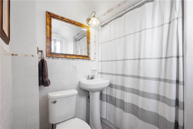 bathroom featuring sink, tile walls, curtained shower, and toilet