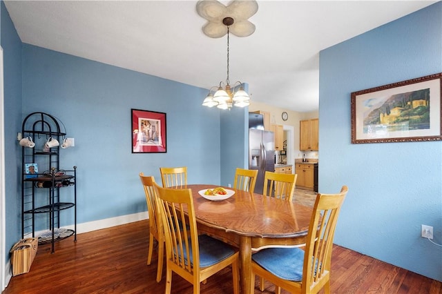 dining room with dark hardwood / wood-style flooring and a chandelier