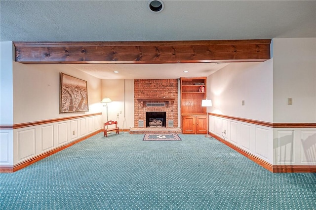 unfurnished living room featuring beamed ceiling, carpet floors, a brick fireplace, and a textured ceiling