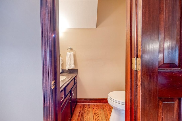 bathroom featuring vanity, wood-type flooring, and toilet