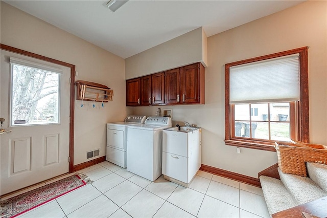 laundry room featuring cabinets, washing machine and clothes dryer, and light tile patterned flooring