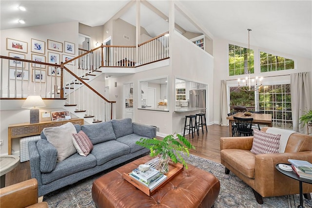 living room featuring hardwood / wood-style flooring, a chandelier, and vaulted ceiling