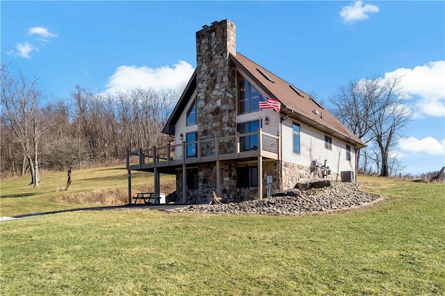 rear view of house with a wooden deck, a yard, and central AC