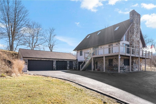 view of front of home featuring a garage, a wooden deck, and a front yard