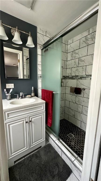 bathroom with vanity and a shower with shower door