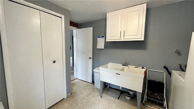 clothes washing area with washer / clothes dryer and cabinets