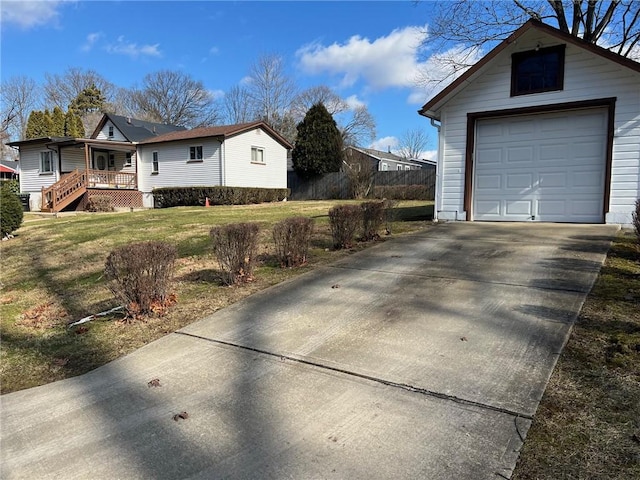 view of side of home featuring a porch, a garage, an outdoor structure, and a lawn