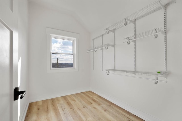 spacious closet featuring hardwood / wood-style flooring and vaulted ceiling