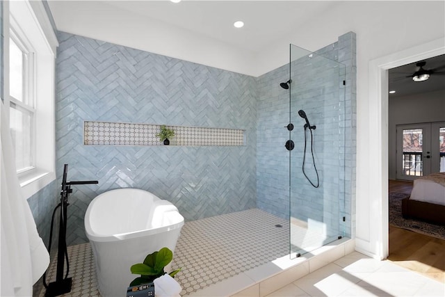 bathroom with tile walls, tile patterned floors, french doors, and separate shower and tub