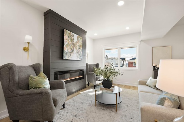 living room with a fireplace and light wood-type flooring