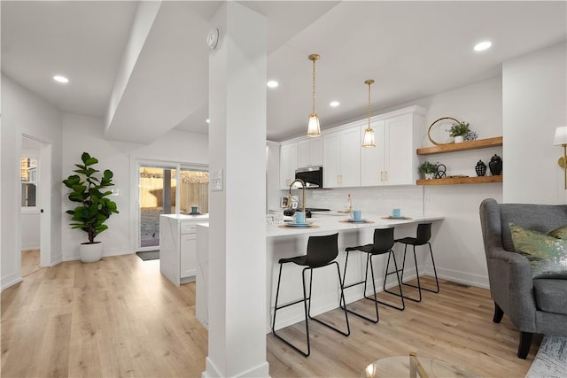 kitchen with white cabinetry, kitchen peninsula, and pendant lighting