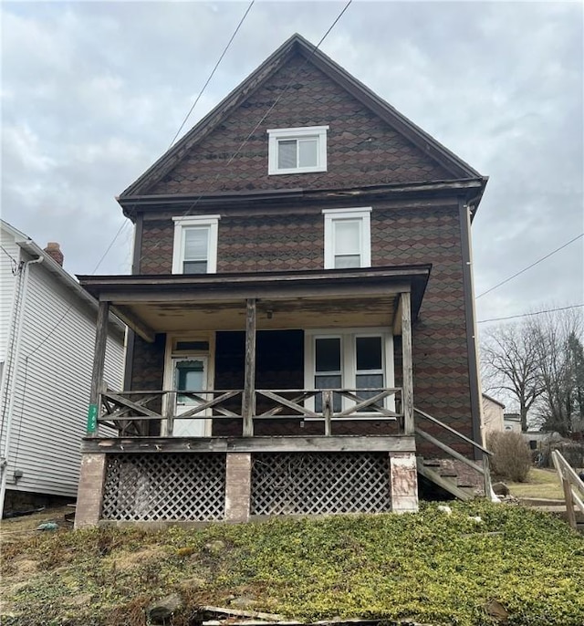 rear view of property featuring covered porch