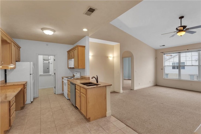 kitchen featuring sink, white appliances, ceiling fan, vaulted ceiling, and light colored carpet