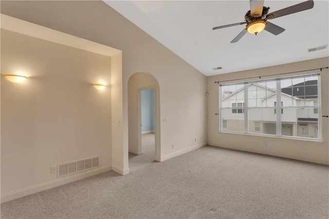 unfurnished room with vaulted ceiling, light colored carpet, and ceiling fan