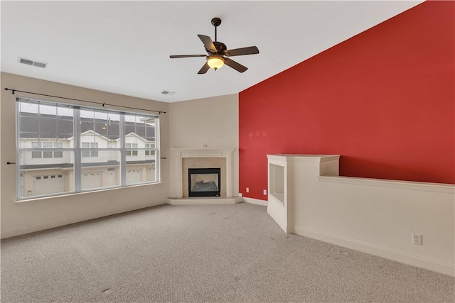 unfurnished living room featuring light colored carpet, a tile fireplace, and ceiling fan