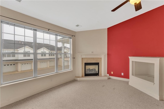 unfurnished living room with ceiling fan, a fireplace, and carpet