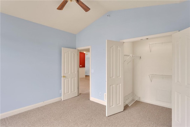 unfurnished bedroom featuring ceiling fan, light colored carpet, vaulted ceiling, and a closet