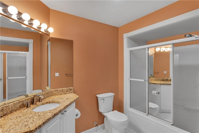 full bathroom featuring vanity, combined bath / shower with glass door, and toilet