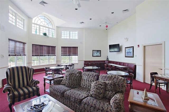 carpeted living room with a towering ceiling and ceiling fan