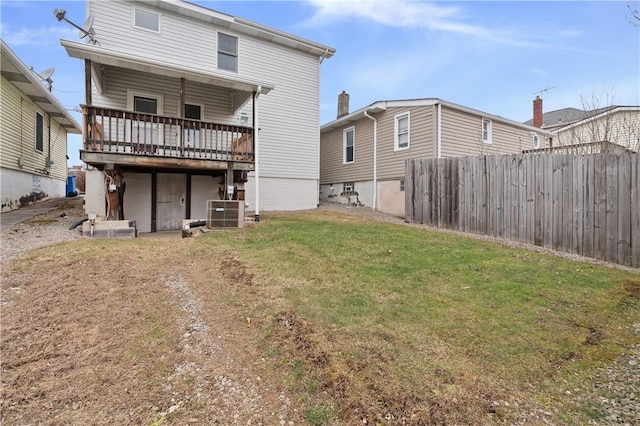 back of property with a yard, central air condition unit, and a deck