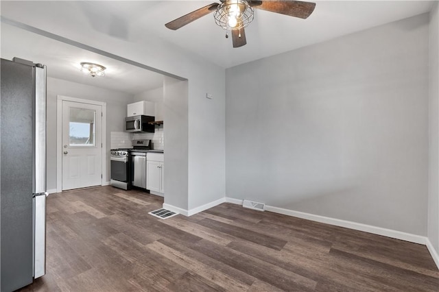 spare room with dark wood-type flooring and ceiling fan