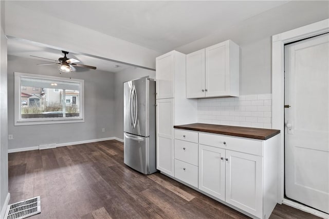 kitchen featuring dark hardwood / wood-style floors, stainless steel refrigerator, tasteful backsplash, butcher block counters, and white cabinets