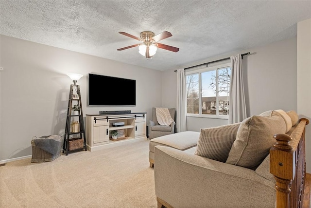 living room with a textured ceiling, light colored carpet, and ceiling fan